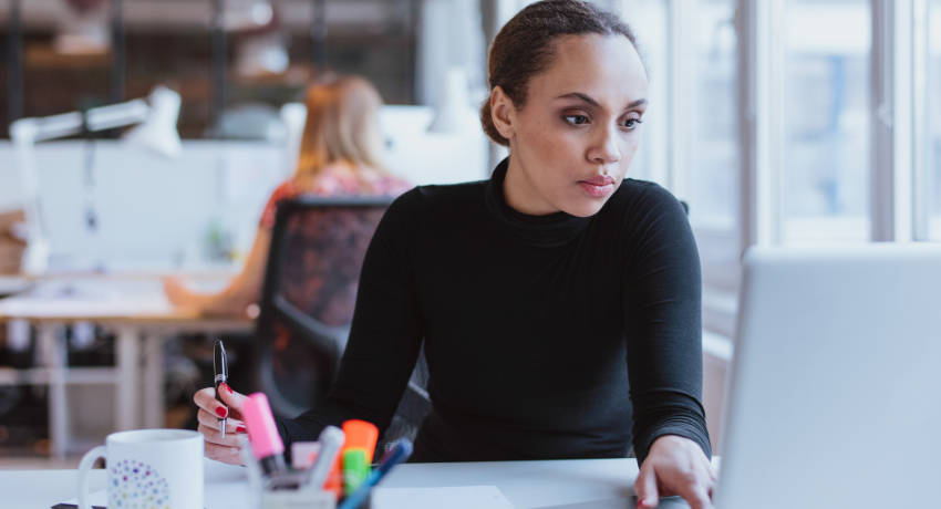 Improving Inclusivity and Accessibility in Digital Learning - woman sat at desk reading from her computer