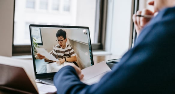 Man presents his work to another person on a video call