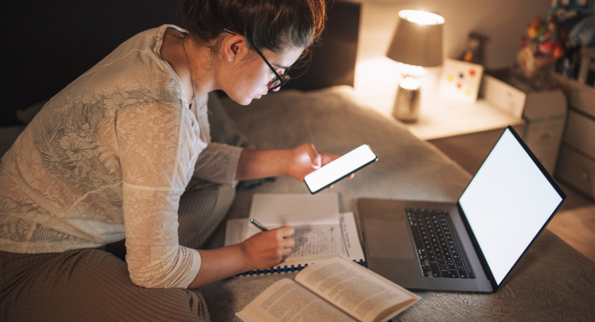 What Is Learner Autonomy and Why Does It Matter - woman sits in front of her laptop taking notes in her notebook