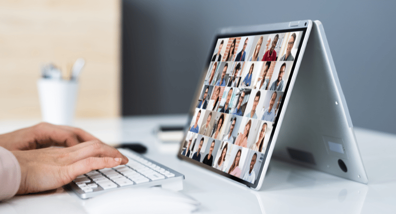 a person on a virtual group call on their tablet, which is stood upright on a table